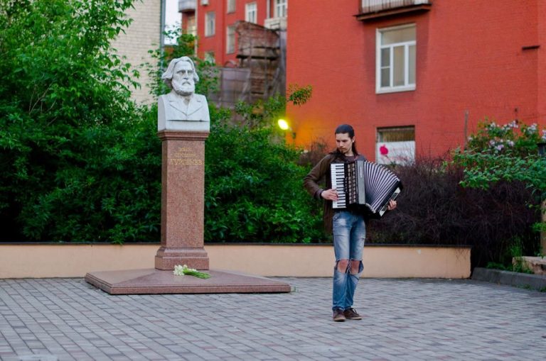 Музыкант с аккордеоном рядом с бюстом Ивана Тургенева