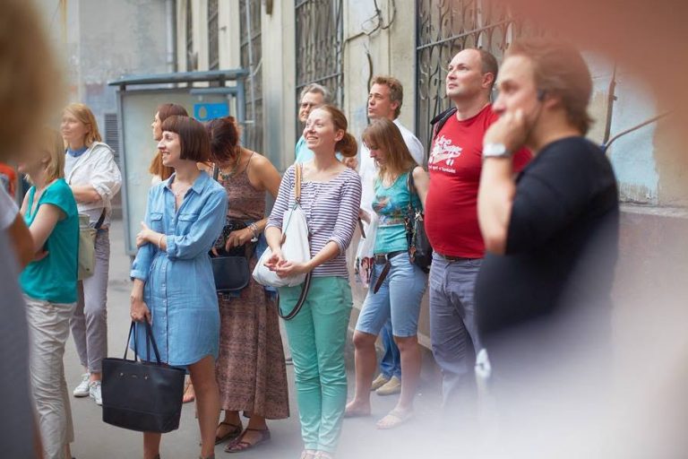 Участники прогулки слушают рассказ экскурсовода