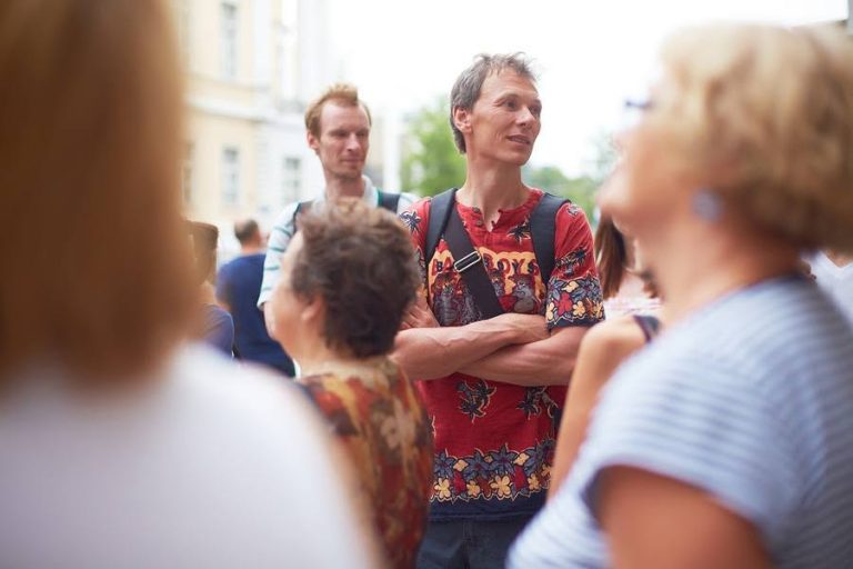 Участник прогулки слушает рассказ на улице Замоскворечья